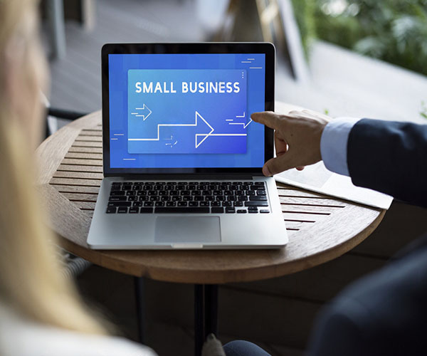 Small business owner viewing their professional website on a laptop showing increased customer inquiries